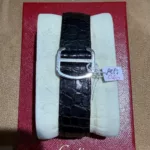 Bracelet noir et boucle déployante de la montre Cartier Tank Solo référence 2715, avec ses papiers Cartier rouges.