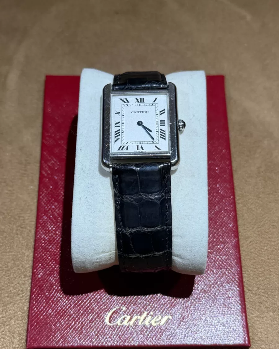 Montre Cartier Tank Solo référence 2715 en acier, vue de face sur ses papiers Cartier rouges.