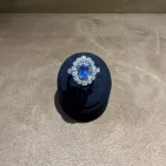 Bague marguerite saphir environ 0,83 ct et diamants présentée dans son écrin