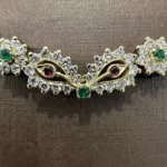 Détail du motif central du collier en or jaune et pierres de couleur